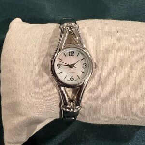 Quartz opal face silver tone ladies bangle watch.